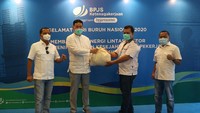 Direktur Pelayanan BPJAMSOSTEK, Krishna Syarif (kedua kiri) menyerahkan paket sembako kepada perwakilan serikat pekerja disaksikan (kiri ke kanan), Anggota Dewan Pengawas BPJamsostek, Rekson Silaban dan Anggota Dewan Pengawas BPJamsostek Eko Darwanto dikantor Pusat BPJamsostek, Jakarta, Jumat (1/5/2020).