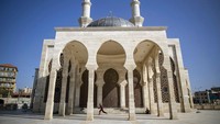 Anak kecil bermain di luar masjid yang ditutup selama pembatasan Corona, di Kora Gaza.