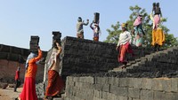 Perempuan India membawa batu bata di kepala, di  di pinggiran Hyderabad, India, Kamis (30/4/2020). Meski dilanda pandemi, para perempuan itu tetap bertahan hidup dengan bekerja keras.  AP / Mahesh Kumar A.