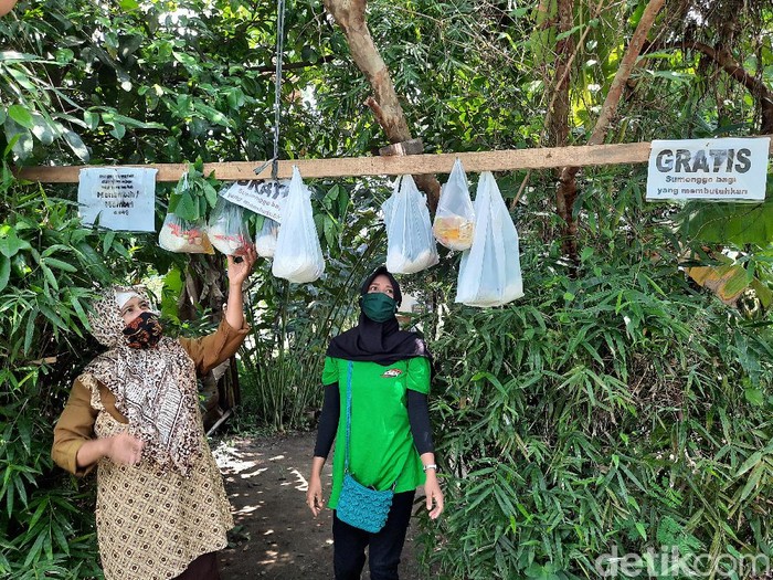 Ardiati menggantungkan beberapa sembako yang dibagikan gratis untuk warga, Jumat (1/5/2020).