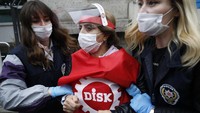 Polisi mengamankan seorang warga yang menggelar aksi May Day saat pandemi Corona di Istanbul. AP Photo/Emrah Gurel.