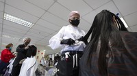 Seorang penata rambut bernama Pornsupa Hattayong bersama sejumlah sukarelawan memberikan layanan potong rambut secara gratis kepada pekerja medis di Rumah Sakit Umum Administrasi Metropolitan Bangkok, Kamis (30/4/2020).