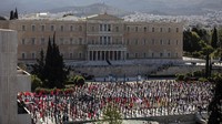  Massa buruh dari serikat PAME memperingati May Day dengan menggelar aksi di luar Parlemen Yunani, Jumat (1/5/2020). AP Photo/Petros Giannakouris.