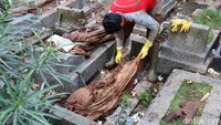 Warga dan petugas terlihat hati-hati mengevakuasi jenazah tersebut. Mereka khawatir jenazah jatuh ke sungai yang berada di bawah pemakaman.