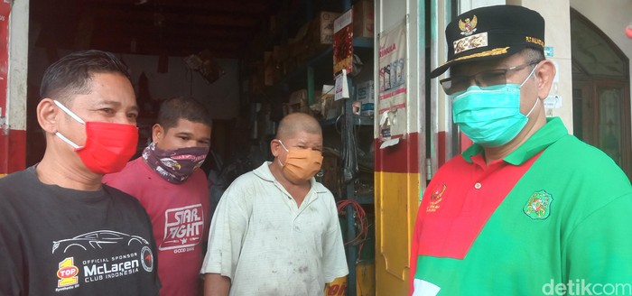 Plt Wali Kota Medan Akhyar Nasution (kanan) memberikan sosialiasi ke warga untuk menggunakan masker.