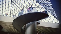 Pengunjung melintasi tangga spiral yang berada di bawah piramida kaca, di Museum Louvre, Paris, 2008. Steve Eason/Hulton Archive/Getty Images