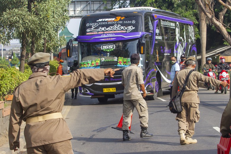 PENYEKATAN JALAN DI PERBATASAN KARAWANG Petugas gabungan mengarahkan bus yang membawa pemudik dari arah Bekasi menuju Karawang untuk berputar arah di Perbatasan Karawang - Bekasi, Jawa Barat, Jumat (24/4/2020). Penyekatan akses transportasi di perbatasan tersebut sebagai tindak lanjut kebijakan larangan mudik yang berlaku bagi kendaraan pribadi, angkutan umum dan motor kecuali mobil pemadam kebakaran, angkutan logistik dan kebutuhan pokok serta ambulan. ANTARA FOTO/M Ibnu Chazar/pras.