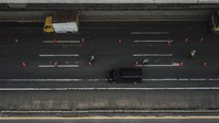 Berikut Foto udara petugas gabungan dari Polisi dan Dinas Perhubungan yang berjaga saat penyekatan pemudik di tol Jakarta-Cikampek, Cikarang, Kabupaten Bekasi, Jawa Barat. Penyekatan akses transportasi tersebut guna membatasi pemudik dari Jakarta yang hendak ke luar kota menggunakan mobil pribadi, angkutan umum, dan motor.  ANTARA FOTO/Fakhri Hermansyah