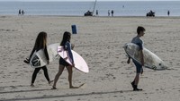 Warga di Pantai Valencia diberi waktu 48 jam untuk keluar rumah dan berolahraga sejak lockdown nasional diterapkan enam minggu lalu. (AFP/JOSE JORDAN)