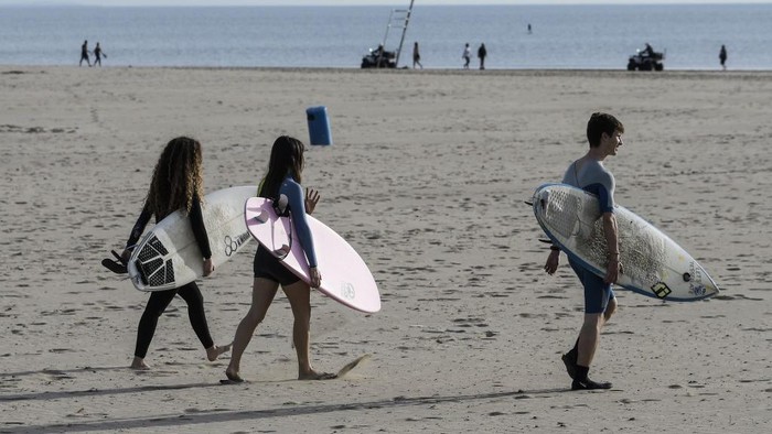 Warga di Pantai Valencia pada 2 Mei 2020 saat jam keluar rumah dan berolahraga untuk kali pertama setelah lockdown nasional untuk memutus rantai virus Corona. Warga Spanyol mendapatkan jatah 48 jam untuk berada di luar rumah. Itu menjadi lanjutan setelah anak-anak di bawah 14 tahun diizinkan keluar rumah sejak 26 April 26 setelah melanjutkan awal lockdown apda 14 Maret. (Photo by JOSE JORDAN / AFP)