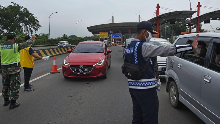 Petugas gabungan memeriksa kendaraan pribadi yang baru keluar dari pintu tol Serang Timur, di Serang, Banten, Rabu (29/4/2020). Penyekatan arus pemudik menuju Banten Selatan dan sekitarnya dilakukan guna menegakkan larangan pemerintah untuk mudik guna mencegah penyebaran COVID-19. ANTARA FOTO/Asep Fathulrahman/aww.