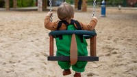 Tampak seorang anak tengah bermain ayunan di taman bermain yang ada di Kota Berlin, Jerman.