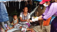 Ketua IKKT PWA Cabang BS II Paspampres Ibu Uli Maruli Simanjutak memberikan makan untuk berbuka puasa kepada masyarakat di pinggir rel kereta api Pasar Gaplok, Senen, Jakarta Pusat, Senin (4/5/2020).