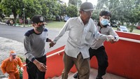 Petugas Dinas Sosial membawa seorang tunawisma yang terjaring razia ke dalam ruang penampungan di GOR Ciracas, Jakarta Timur, Senin (3/5/2020). 