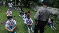 Petugas Kepolisian memberikan arahan kepada para pelajar SMA yang terjaring razia saat mau pesta kelulusan dengan corat-coretan. Duh, akhirnya ditangkep kan, sama pak Polisi.