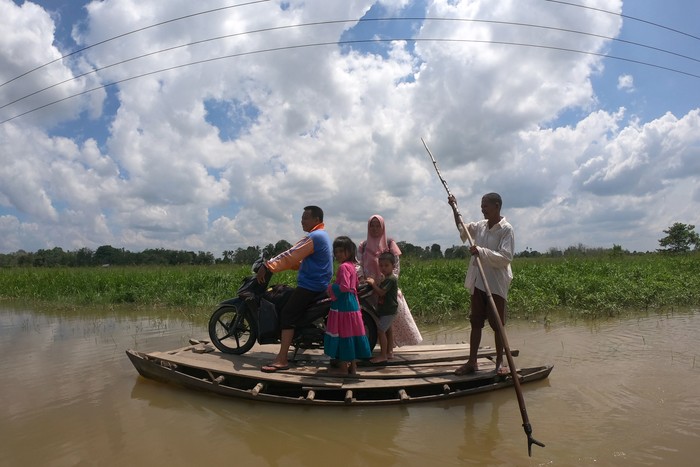 JALAN TERPUTUS AKIBAT BANJIR Penyedia jasa perahu penyeberangan mengantarkan penumpang melintasi jalan penghubung Desa Jebus dengan Desa Gedong Karya yang terendam banjir di Muarojambi, Jambi, Senin (4/5/2020). Jalan penghubung desa satu-satunya di perbatasan Kabupaten Muarojambi dengan Kabupaten Tanjungjabung Timur itu terendam banjir luapan Sungai Batanghari dalam tiga pekan terakhir yang mengakibatkan akses jalan terputus untuk kendaraan atau hanya bisa dilewati perahu dan orang. ANTARA FOTO/Wahdi Septiawan/pras.