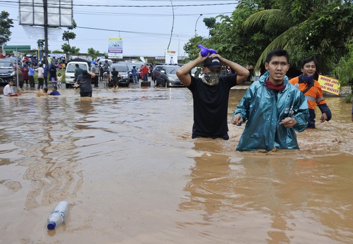 Warga berjalan menerobos banjir di Kotasari, Grogol, Cilegon, Banten, Senin (4/5/2020). Banjir yang terjadi akibat tanggul Kali Ciore jebol setelah diguyur hujan sejak Minggu (3/5) malam itu mengakibatkan ratusan rumah dan jalan terendam air setinggi 40-110 centimeter. ANTARA FOTO/Asep Fathulrahman/pras.
