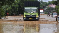 Warga memandu sopir truk melewati banjir di Jalan Cilegon-Merak, Grogol, Cilegon, Banten, Senin (4/5/2020).