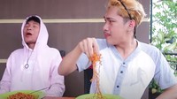 Mulai kewalahan dengan sengatan pedas dari bumbu Samyang dan bubuk cabe, Ferdian mulai menyantap mie pakai tangannya. Foto: YouTube Ferdian Paleka