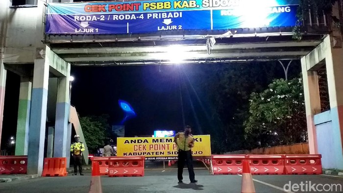 Memasuki hari kelima dan keenam penerapan PSBB di Sidoarjo, petugas memblokade total akses jalan di Waru pada malam hari. Suasana lengang bak lockdown sangat terasa.