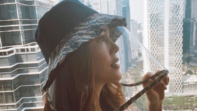 Cathy Sharon mengenakan topi yang dilengkapi face shield. Produk yang disebut topi Corona ini bermotif batik dan merupakan keluaran dari brand lokal Alleira. Foto: Instagram/@cathysharon