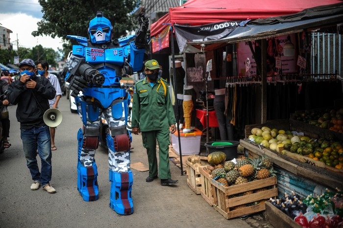 ROBOT SATGAS ANTI NONGKRONG Petugas keamanan yang tergabung dalam Satuan Tugas Anti Nongkrong mengenakan kostum robot saat berpatroli keliling kampung di Sekepanjang, Bandung, Jawa Barat, Senin (4/5/2020). Karang Taruna serta pengurus RW setempat melakukan cara unik dengan berpakaian kostum robot untuk memberikan imbauan kepada warga agar menghindari kerumunan serta tetap berada di rumah guna menekan angka penyebaran COVID-19. ANTARA FOTO/Raisan Al Farisi/wsj.