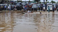 Sejumlah warga berdiri menunggu banjir surut di Kotasari, Grogol, Cilegon, Banten, Senin (4/5/2020).