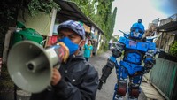 Petugas keamanan yang tergabung dalam Satuan Tugas Anti Nongkrong mengenakan kostum robot akan berpatroli keliling kampung di Sekepanjang, Bandung, Jawa Barat, Senin (4/5/2020). Siapa yang masih nekat nongkrong, siap-siap diciduk.