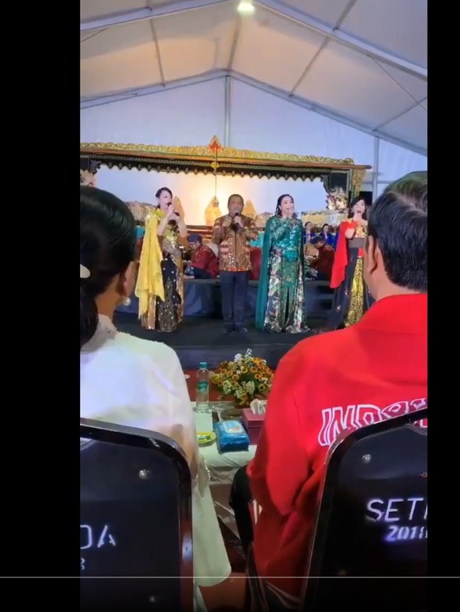 Yan Vellia sering terlihat mendampingi Didi Kempot naik ke atas panggung. Wanita berambut panjang ini juga berprofesi sebagai penyanyi. Salah satu aksinya menyanyi bareng Didi Kempot diunggahnya ke akun Twitternya. Dia dan sang suami tampak duet menyanyikan lagu Cucak Rowo di depan Presiden Jokowi. Foto: Dok. Twitter