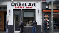 Warga yang akan mencukut rambut mengantre dengan tetap menerapkan social distancing. Sean Gallup/Getty Images.