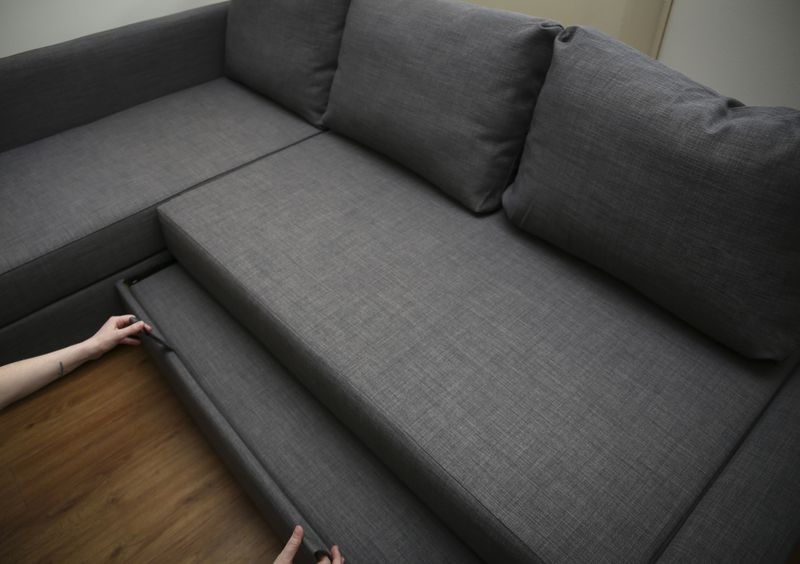 Blue sofa and wicker carpet in white simple living room