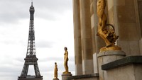 Patung-patung di Lapangan Trocadero menggunakan masker, Paris, Prancis (4/5/2020). Di seberangnya terlihat Menara Eiffel yang kesohor itu. AP Photo/Christophe Ena.