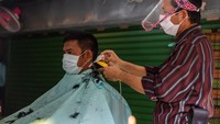 Jasa pemotongan rambut kembali di serbu setelah pemerintah Thailand melonggarkan lockdown. Meski begitu, pemotong rambut dan pelanggan tetap wajib memakai masker untuk mencegah penularan virus Corona. Lauren DeCicca/Getty Images.  