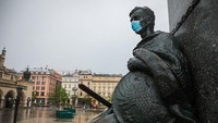 Patung dari legenda kisah Adam Mickiewicz menggunakan masker di Krakow, Polandia (1/5/2020). Beata Zawrzel/NurPhoto via Getty Images.