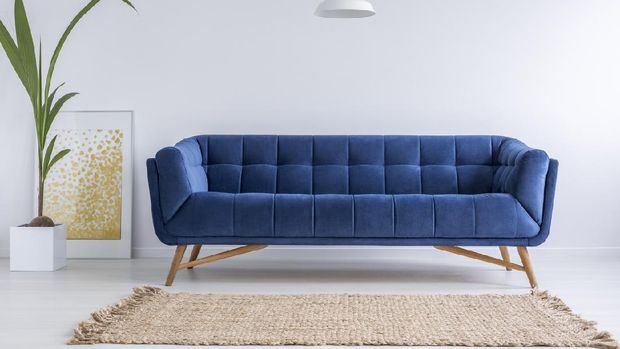 Blue sofa and wicker carpet in white simple living room