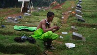 Usai melakukan penggalian, mereka tetap beristirahat di area pemakaman. Sesekali mereka menanyakan kabar keluarga dengan smartphonenya.