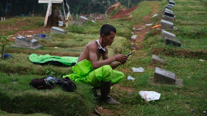 Penggali kubur untuk korban virus Corona disiagakan di TPU. Mereka dengan sigap menggali liang lahat saat ada jenazah yang akan dimakamkan. Begini potretnya.