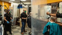 Jasa pemotongan rambut di Spanyol melakukan penyekatan dengan plastik transparan. Penyekatan itu juga untuk mengantisipasi penyebaran virus Corona. Sean Gallup/Getty Images.