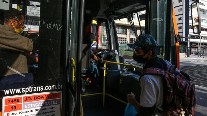 Seorang penumpang dengan mengenakan masker berjalan di stasiun kereta bawah tanah di tengah-tengah pandemi COVID-19 pada 4 Mei 2020 di Sao Paulo, Brasil.