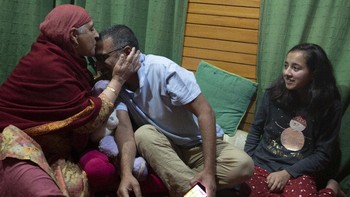 Fotografer Dar Yasin mendapat kecupan dari ibunya di Srinagar. AP Photo/Rifat Yasin.