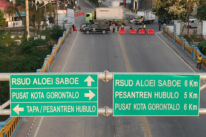 PENUTUPAN JALAN DI GORONTALO Foto udara sejumlah Polisi, Dinas Perhubungan dan Satpol PP berjaga di jembatan perbatasan Kota dan Kabupaten Gorontalo di Telaga, Kabupaten Gorontalo, Gorontalo, Rabu (6/5/2020). Sejumlah jalan utama di kedua wilayah tersebut ditutup dari pukul 17.00 hingga 06.00 WITA seiring penerapan Pembatasan Sosial Berskala Besar (PSBB) guna memutus mata rantai pandemi COVID-19. ANTARA FOTO/Adiwinata Solihin/foc.