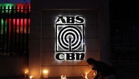 Seorang karyawan menyalakan lilin di kantor pusat ABS-CBN di Manila.