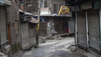 Seorang lelaki tua Kashmir duduk di luar pasar tertutup selama pemogokan di Srinagar, Kashmir yang dikuasai India, 17 Februari 2019. AP Photo/Dar Yasin.