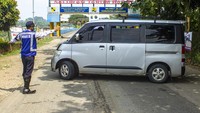Petugas gabungan mengarahkan pemudik roda empat yang akan melewati titik pemeriksaan untuk berputar arah di perbatasan Bekasi - Karawang, Jembatan Siphon, Telukjambe Barat, Karawang, Jawa Barat.