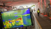 Warga yang melintas di sepanjang terowongan Kendal, Stasiun Sudirman terpantau suhu tubuhnya di monitor alat deteksi suhu tubuh thermoscan saat menggelar rapid test massal di Terowongan Kendal, Jakarta, Rabu (6/5/2020). Hal itu terus dilakukan secara masif lantaran kasus positif COVID-19 di Jakarta masih tinggi.