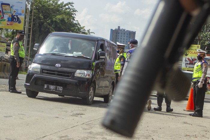 Petugas mengarahkan penumpang kendaraan roda empat untuk melakukan pembatasan sosial atau physical distancing di titik pemeriksaan di Gerbang tol Karawang Barat, Karawang, Jawa Barat, Rabu (6/5/2020). Petugas gabungan memperketat akses keluar masuk kendaraan yang akan melewati gerbang tol pada hari pertama pemberlakuan Pembatasan Sosial Berskala Besar (PSBB) di Karawang. ANTARA FOTO/M Ibnu Chazar/foc.