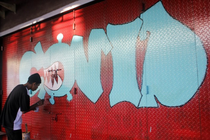Saat Pintu Toko yang Tutup Imbas Corona Jadi Media Seni Mural Ditengah masa pandemi virus Corona, sejumlah pemuda Papua Barat menyulap pintu pertokoan yang tutup dengan kreatifitas karya seni Mural.