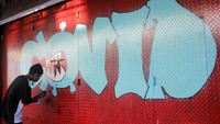 Seorang pemuda melukis Mural tentang COVID-19 di kawasan pertokoan yang tutup akibat wabah COVID-19, di Kota Sorong, Papua Barat, Selasa (5/5/2020).  