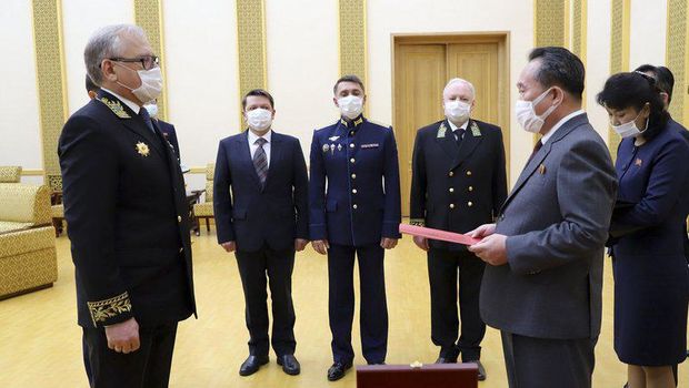 Penyerahan medali perang dunia kdua untuk Kim Jong Un. Semua menggunakan masker (AP)