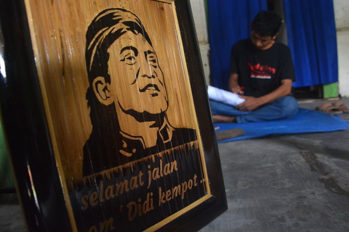 UKIRAN BAMBU DIDI KEMPOT Anang Setyo Pambudi menyelesaikan ukiran pada bambu bergambar wajah almarhum Didi Kempot di Desa Sumberjo, Kabupaten Jombang, Jawa Timur, Rabu (6/5/2020). Ukiran bambu sketsa wajah Didi Kempot yang dibuat seniman tersebut rencananya akan dikirimkan ke pihak keluarga di Ngawi untuk mengenang maestro campursari itu. ANTARA FOTO/Syaiful Arif/aww.